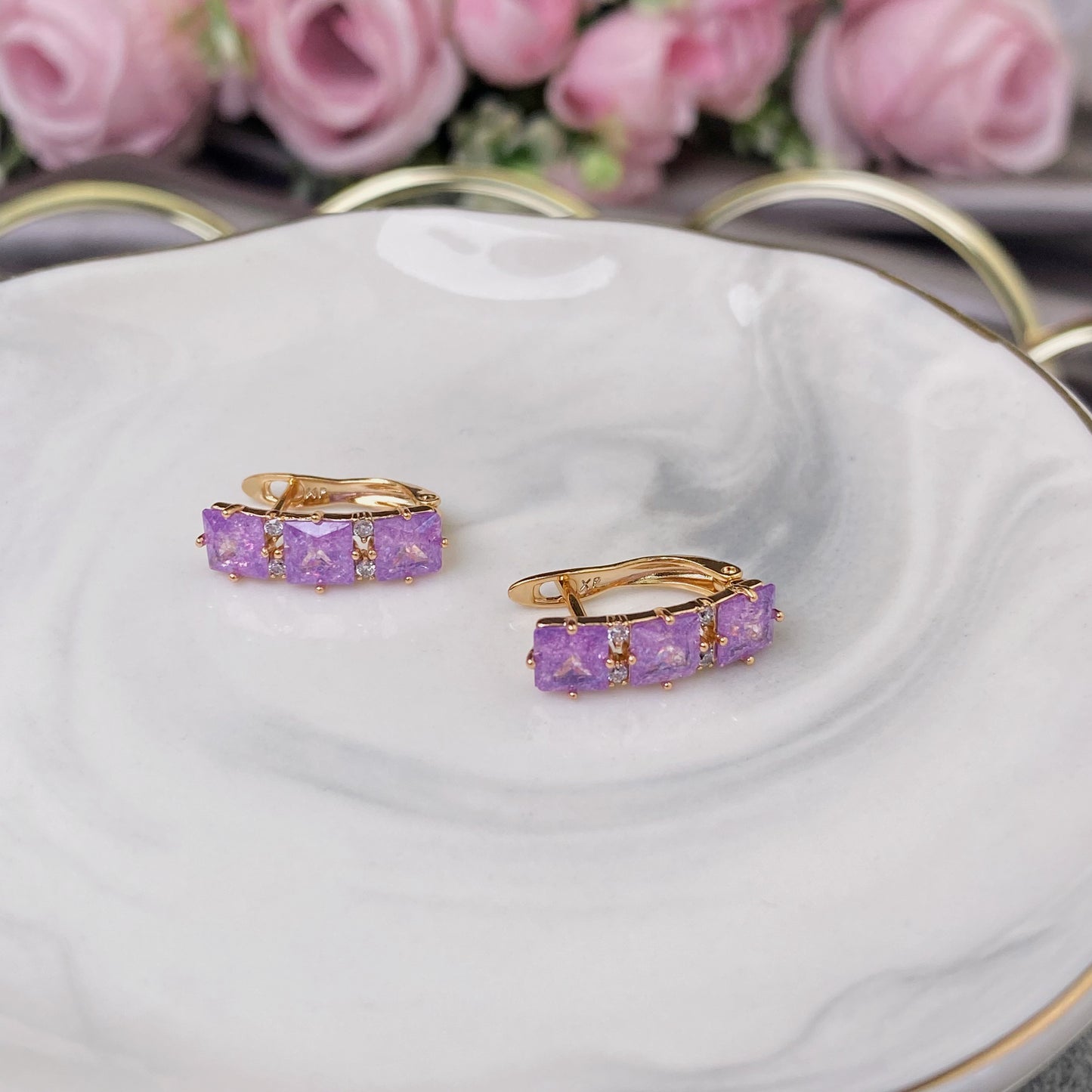 Vergoldete Ohrringe mit violetten Zierkristallen